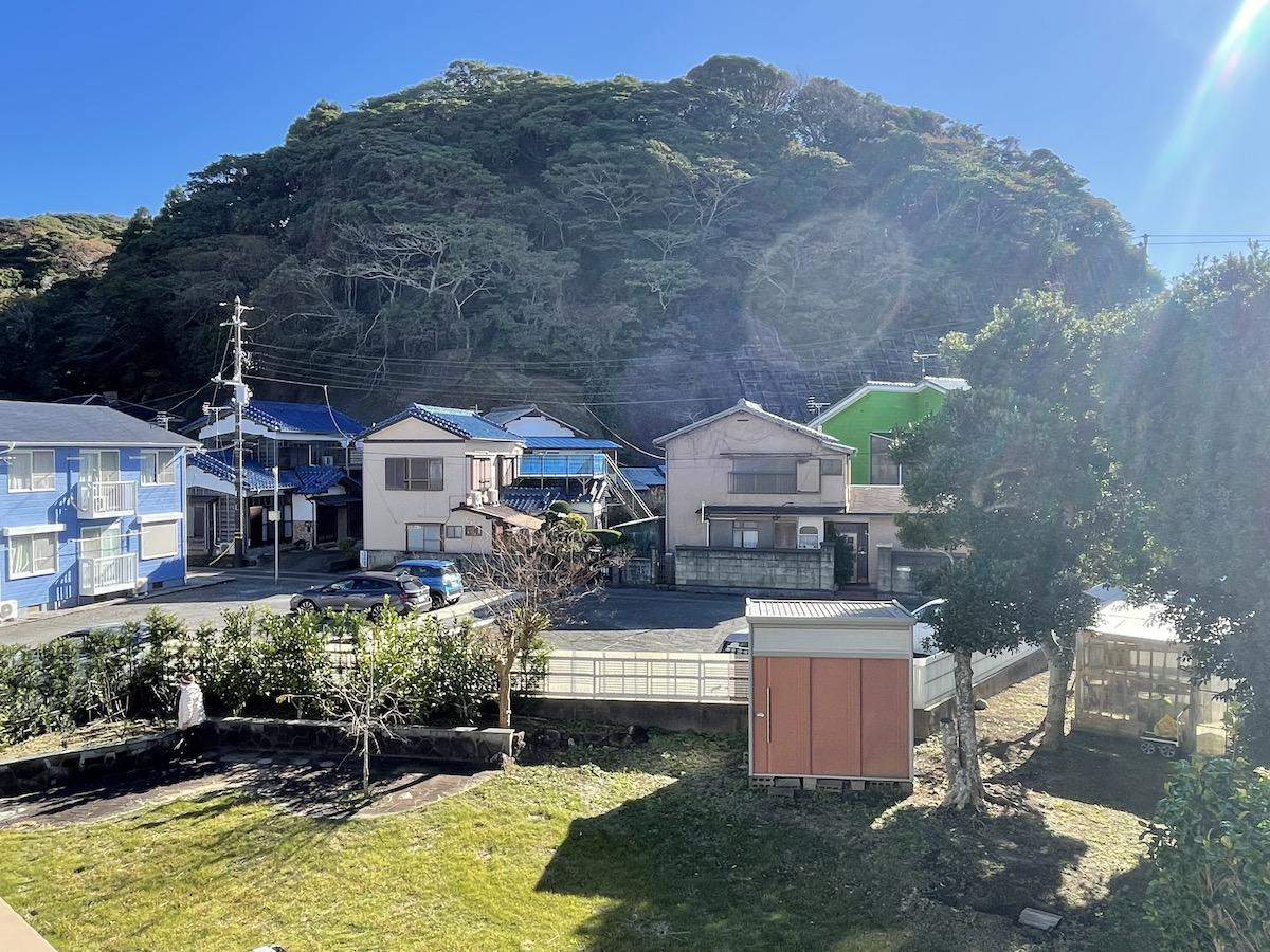 千葉県勝浦市浜勝浦の売買物件/ベランダから庭を眺める。奥にはこんもりとした山が