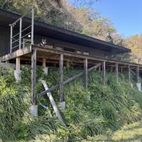 千葉県富津市竹岡の売買物件/物件敷地脇の道から母屋とテラスを見上げる。テラスは広く、舞台のよう