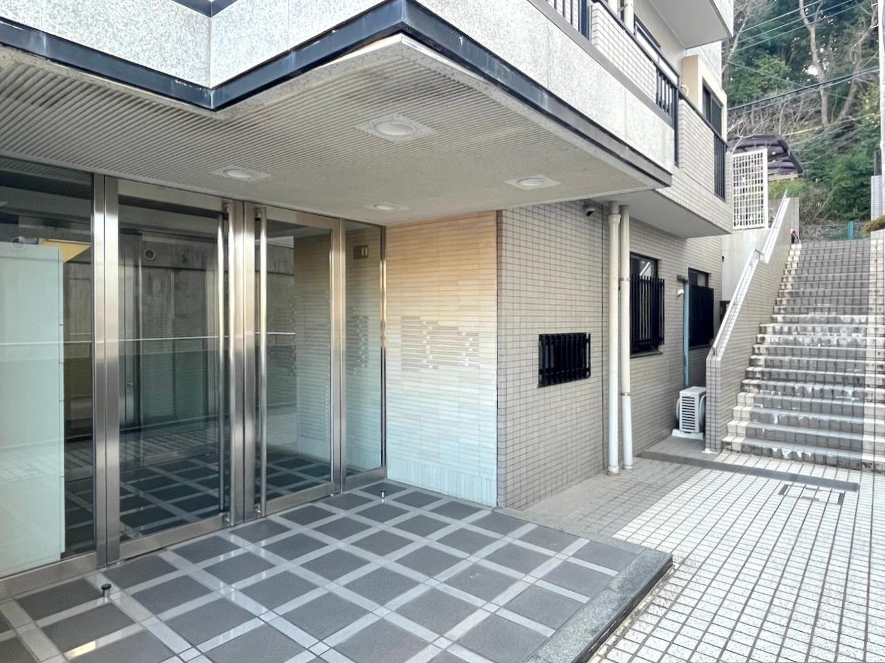 福岡市南区多賀の売買物件/階段を降りてから玄関エントランス。現在大規模修繕中です。