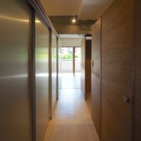 福岡市中央区梅光園団地の売買物件/木とアルミに挟まれた通路の先に、窓辺の光。