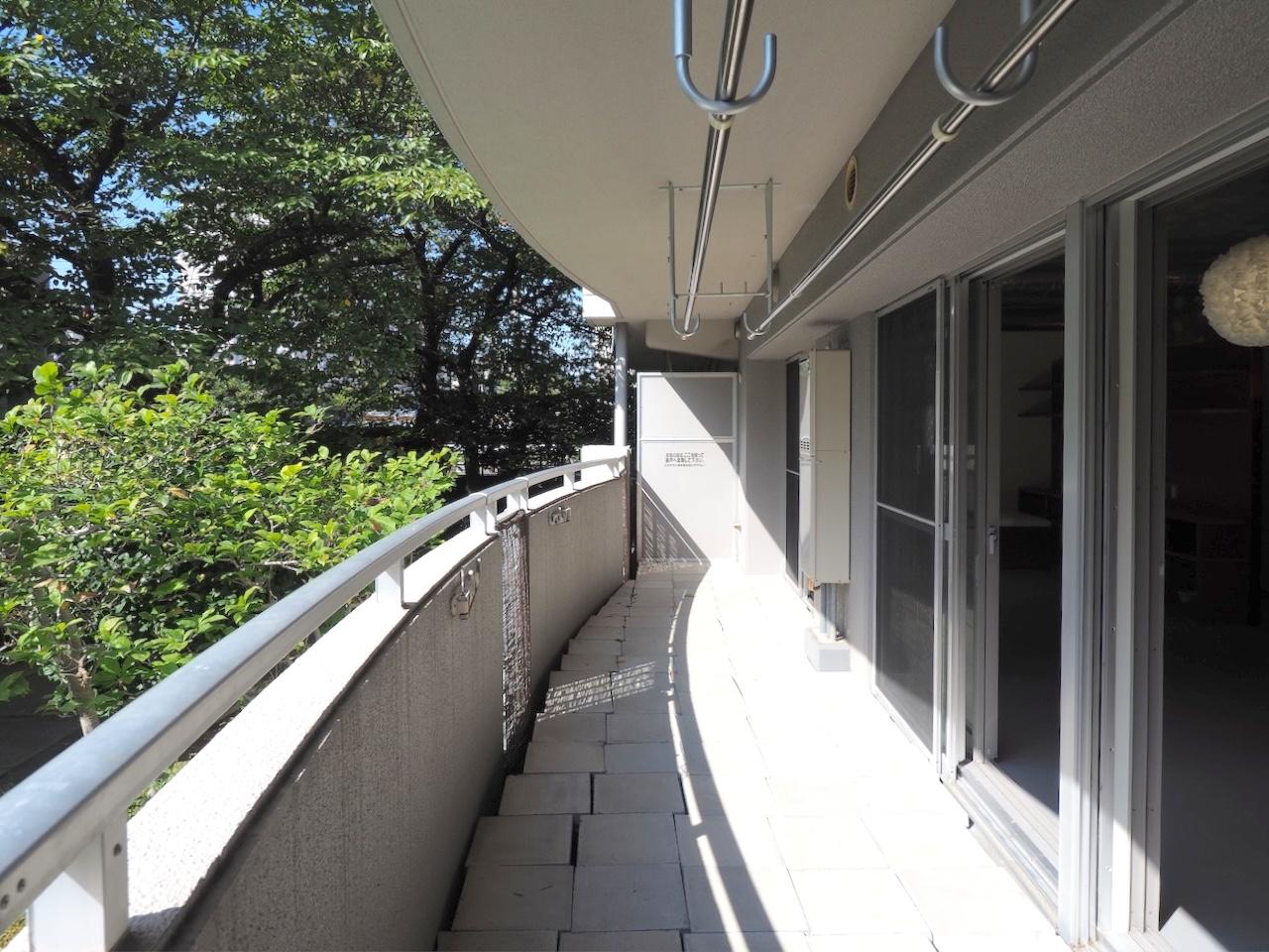 福岡市中央区梅光園団地の売買物件/住戸の幅いっぱいに延びるバルコニー。木々がすぐ近くに。