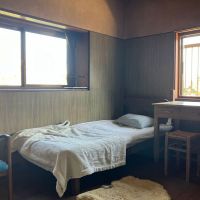 鎌倉市扇ガ谷四丁目の賃貸物件/2階洋室｜2面窓で明るいです。ベッドと書き物机のある落ち着きそうな部屋。