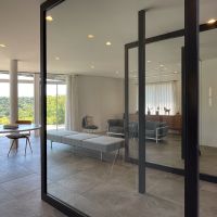 葉山町下山口の売買物件/1階リビングとホールのパーテーションは大きなアイアン製の回転扉。開放時