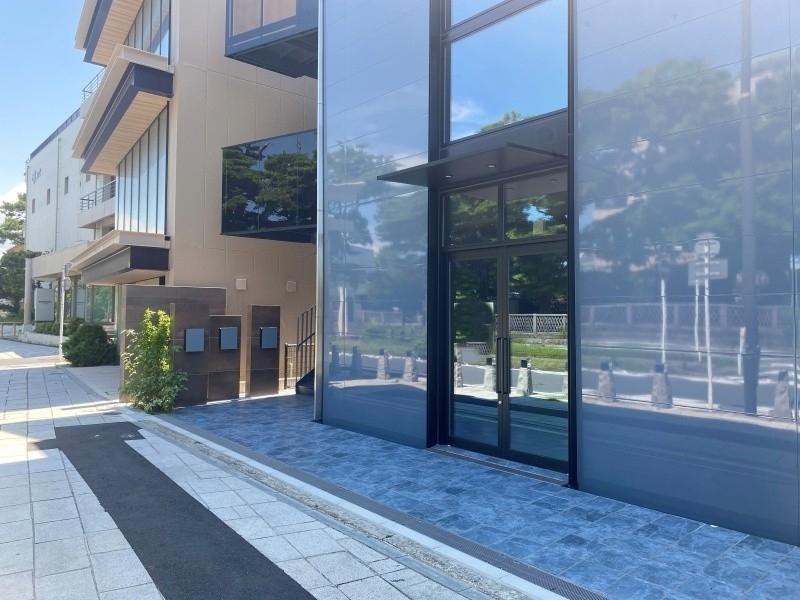 鎌倉市由比ガ浜二丁目の賃貸物件/通行人や行き交う車、空の様子や沿道の木々を外壁が映しています