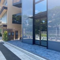 鎌倉市由比ガ浜二丁目の賃貸物件/通行人や行き交う車、空の様子や沿道の木々を外壁が映しています
