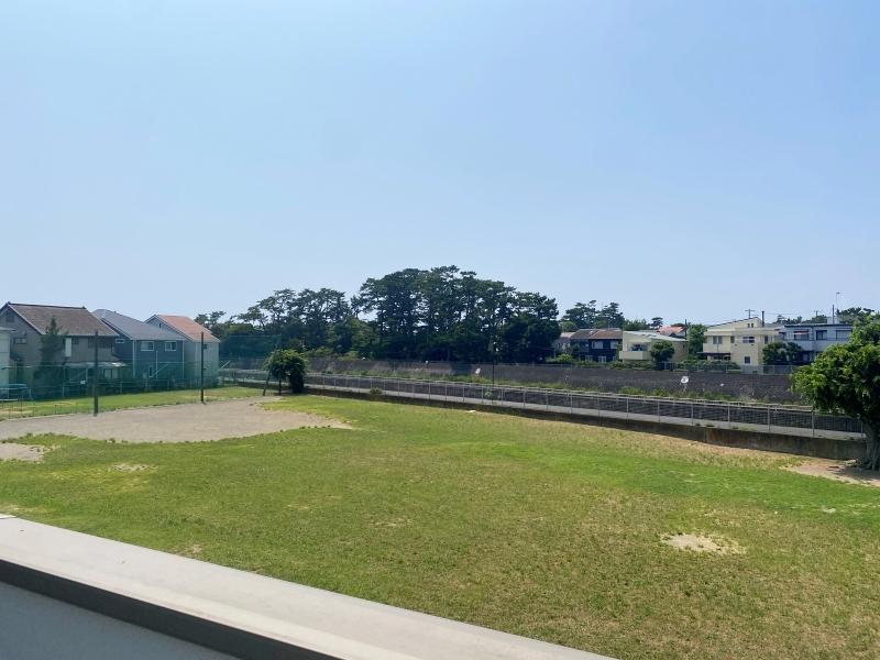 藤沢市片瀬五丁目の売買物件/ルーフバルコニーから広場で遊ぶ子どもたちや川沿いをランニングする人、犬の散歩をする人の様子が見えます
