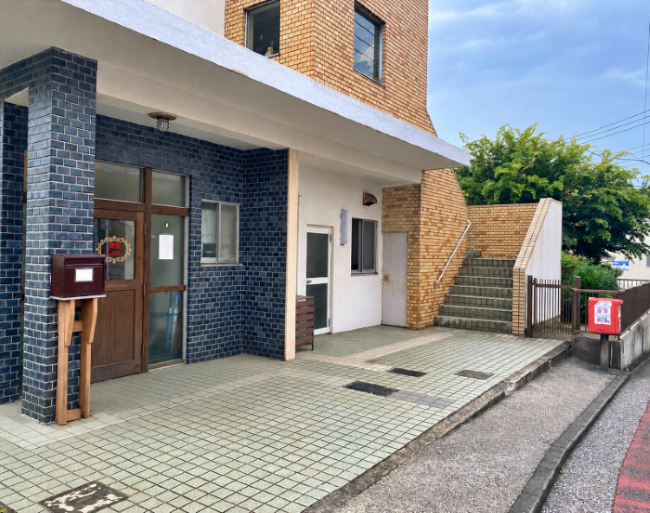 横浜市金沢区寺前一丁目の賃貸物件/駐車場│建物前のスペースを使用可。元はアルミ製の扉でしたが、木の扉と木枠に更新され、ぐっと親しみやすい雰囲気になっています