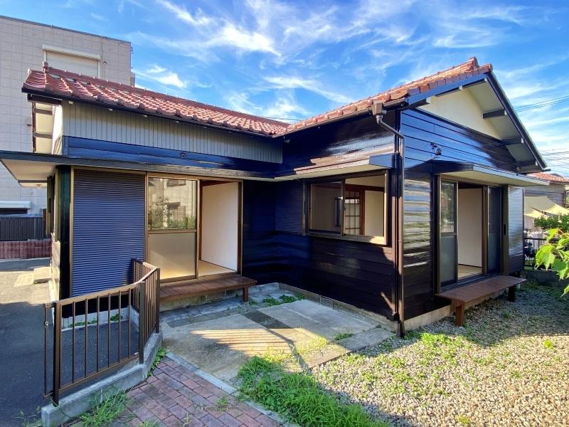 鎌倉市腰越四丁目の賃貸物件/外観│赤褐色の瓦屋根に黒い外壁。庭に向かって縁側が2つ付いています
