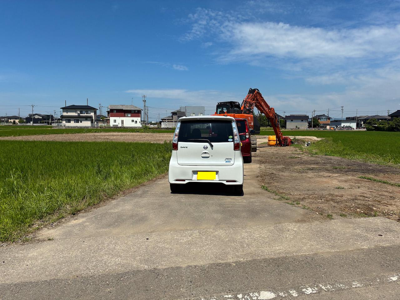 富山県砺波市の売買物件/農道（公衆用道路）の奥の宅地と、その周りの田んぼ。