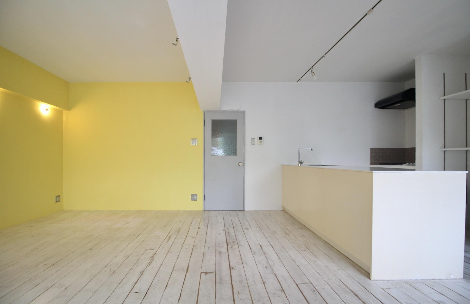 神戸市垂水区塩屋町の売買物件/アイランドキッチンを中心に、淡いグレーの建具とイエローの差し色が効いた、遊び心のある空間