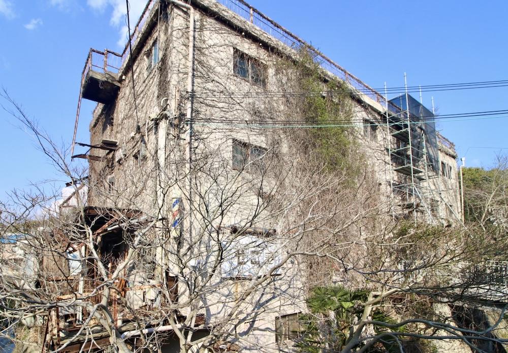 神戸市垂水区塩屋町の売買物件/川沿いにそびえ立つ、蔦に覆われて荒廃した外観。