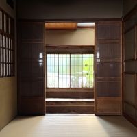 京都市北区紫野南舟岡町の賃貸物件/玄関土間には腰掛が配置されています。窓越しに映るグリーンも良い。
