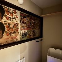 京都市上京区東今⼩路町744-28の賃貸物件/改装前の壁に貼られていた昔のチラシをそのまま残し、額縁をつけてアートとして活かしたトイレ空間。