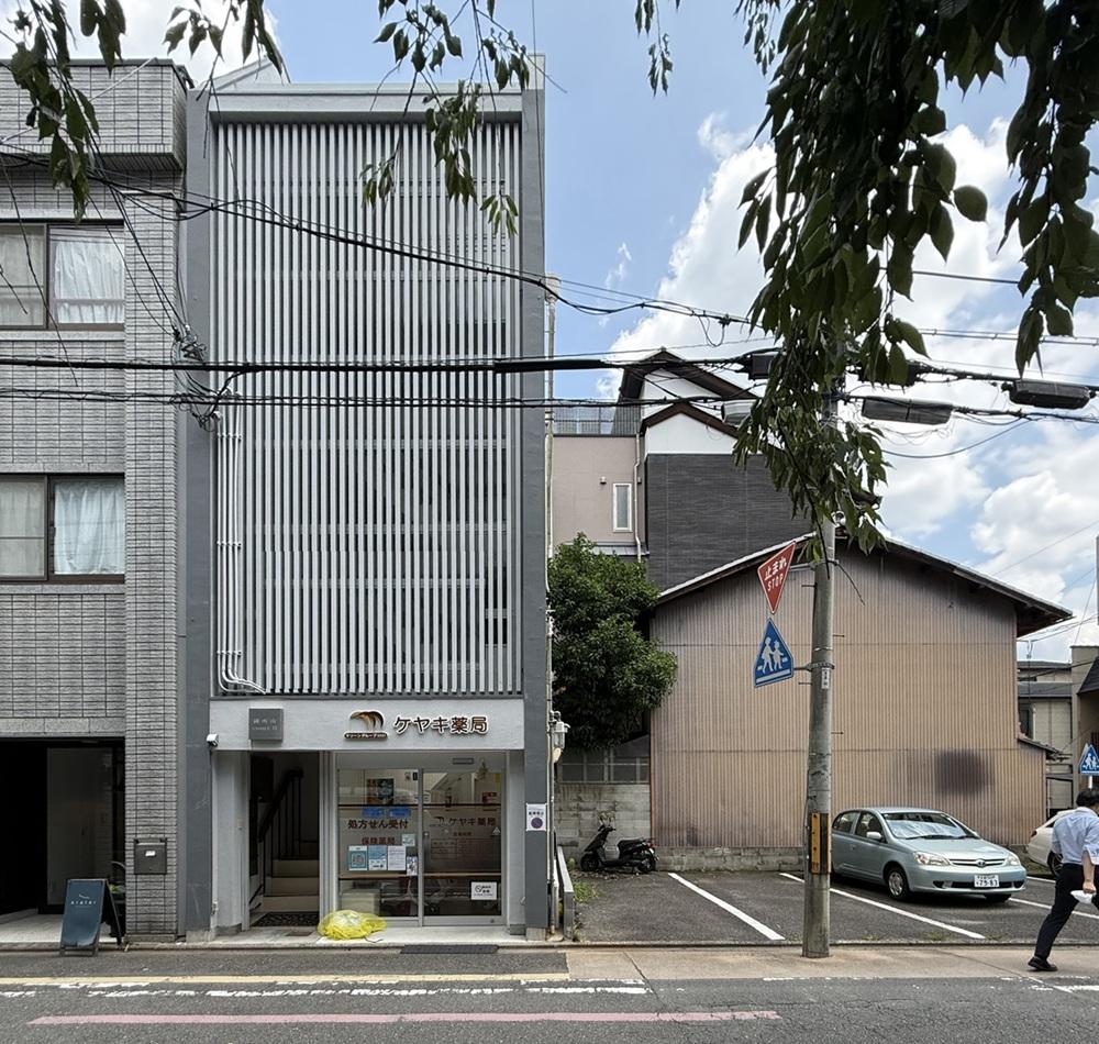 京都市中京区富小路竹屋町上る桝屋町325-2 の賃貸物件/外観全景。1階には薬局が入っています。左手階段が上階への入り口。建物のセットバックはないので、自転車を置くスペースがありません。