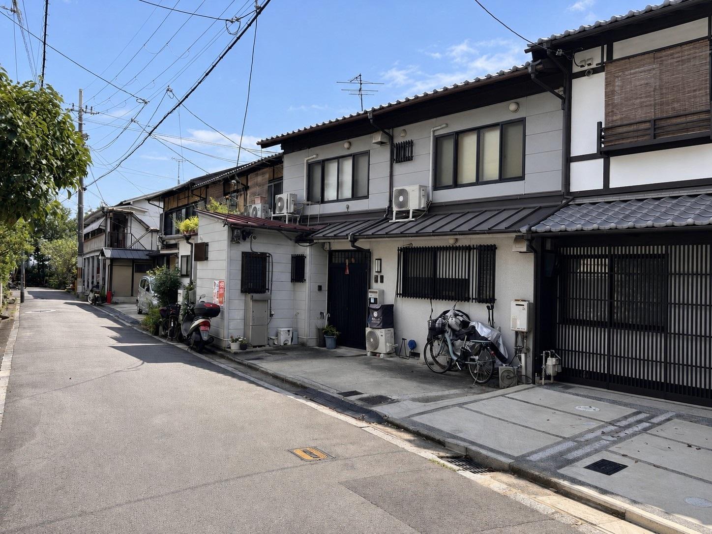 京都市左京区吉田中大路町34-109、他の売買物件/前面道路から見た連棟。該当物件は写真右端で、左手には吉田山の緑が迫ります。