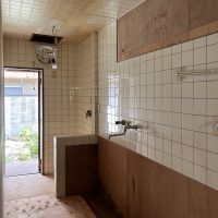 京都市左京区鹿ケ谷西寺ノ前町14の売買物件/1F｜タイル壁や収納が残る台所。奥の扉から庭へ出られます。