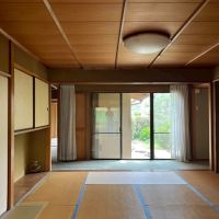 京都市右京区嵯峨二尊院門前善光寺山町7-23の売買物件/ここが1階中心にある8帖の居間（キッチン側からの画）。掃き出し窓の向こうの壁は増築された小部屋。