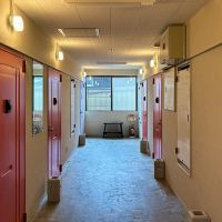 京都市北区上賀茂薮田町11-1の賃貸物件/赤い扉が並ぶ共用廊下。共用部にまでこの建物らしさがちらり