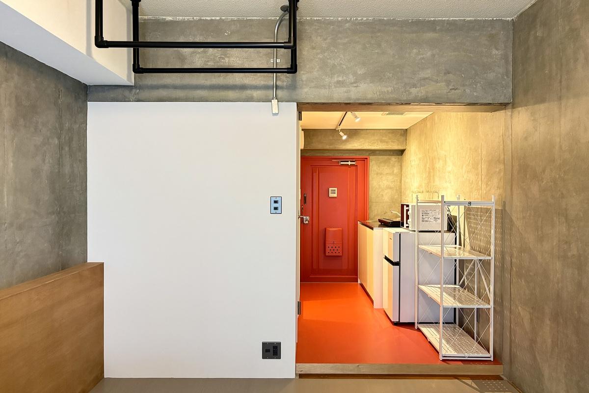 京都市北区上賀茂薮田町11-1の賃貸物件/赤い床と玄関ドアがアクセント。無骨なコンクリートとの組み合わせがいい感じ