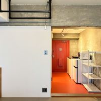 京都市北区上賀茂薮田町11-1の賃貸物件/赤い床と玄関ドアがアクセント。無骨なコンクリートとの組み合わせがいい感じ