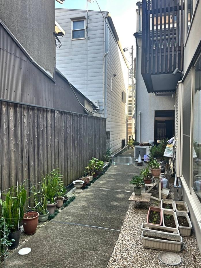 京都市上京区御前通仁和寺街道下る三筋目東入る西上之町278-5の賃貸物件/玄関から見る通路。前道に面したお宅はオーナーの親族がお住まい。朝夕の挨拶があると気分も良くなりそう。