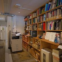 渋谷区代官山町の賃貸物件/共用の複合機、書棚。棚には建材のサンプルなどもあります
