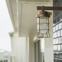 沖縄県那覇市首里崎山町の売買物件/玄関には既存のブルーのレトロタイル&times;真鍮製の船舶照明の外灯を