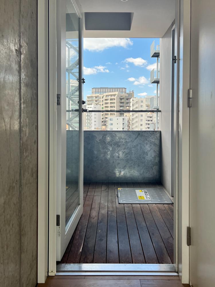 江東区門前仲町の賃貸物件/エレベーターから玄関までの屋外廊下はウッドデッキ。ベランダはありませんが、ワンフロア1住戸なので実質専有のような形で使えます。他の居住者さんはここに自転車など置いているようでした。エレベーターは居住階にだけ停まるのでセキュリティも安心です。