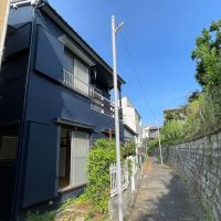 板橋区赤塚の賃貸物件/曲がりくねった味のある小道。建物の外装はキレイなネイビーで塗装されています