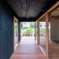 埼玉県入間市鍵山の売買物件/格子の扉を開けると半屋外の中廊下。左が離れ、右側のガラス扉が階段ホールに通じています