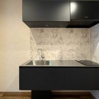 港区高輪の賃貸物件/コンロはIH、レンジフードに高さを合わせた吊戸棚など、全体的にスッキリまとまったキッチン