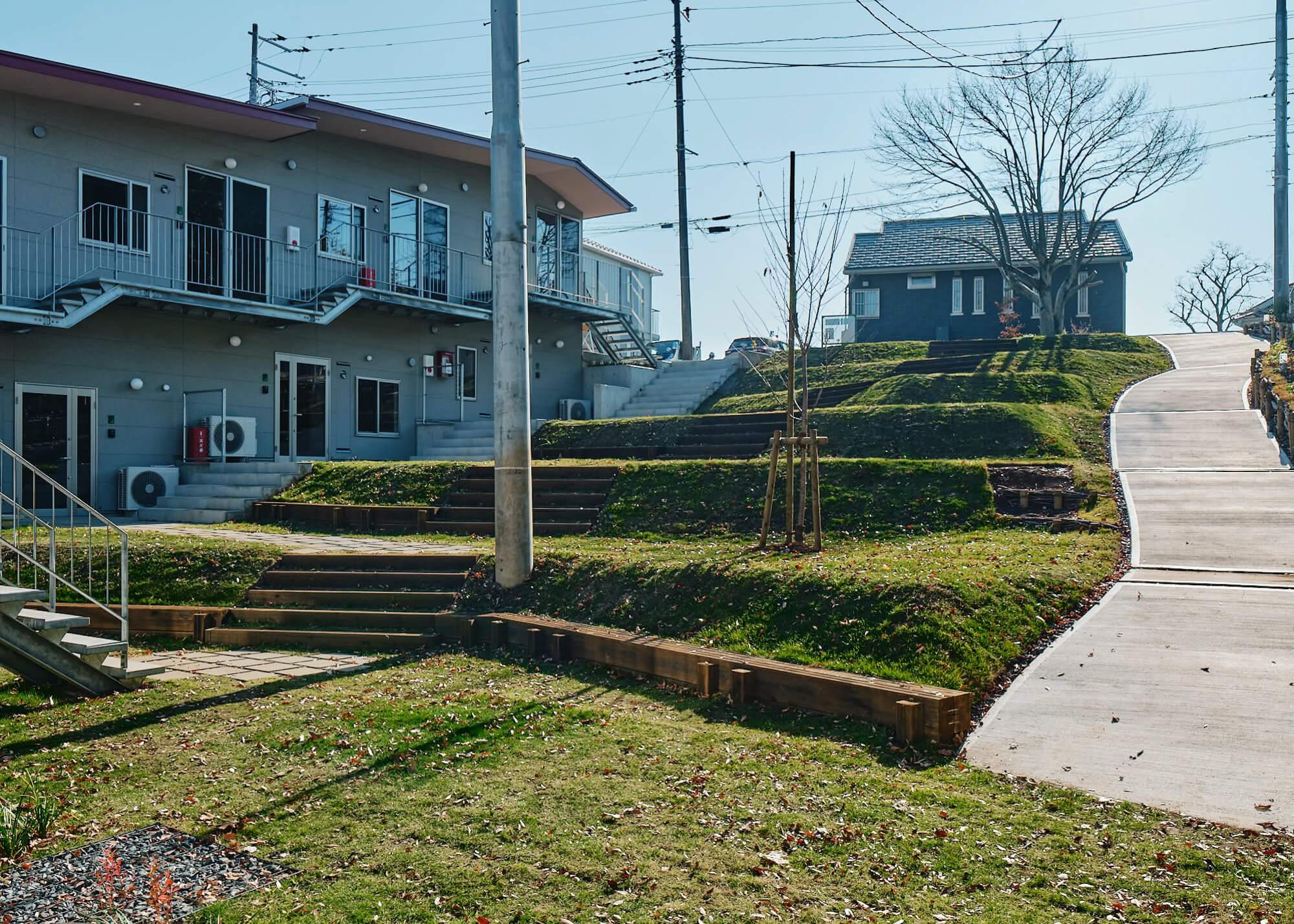 神奈川県横浜市港北区篠原町の賃貸物件/庭棟から敷地内を眺める。芝生が張られて腰をかけれる広場のようになっている