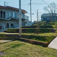 神奈川県横浜市港北区篠原町の賃貸物件/庭棟から敷地内を眺める。芝生が張られて腰をかけれる広場のようになっている
