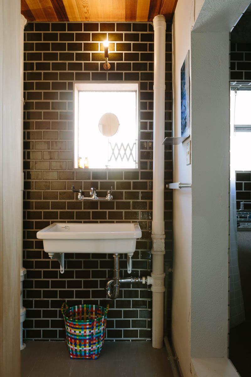 千葉県美浜区幸町の売買物件/むき出しの配管が活きるタイル張りのトイレ空間。小さな窓もどこか海外のアパルトマンのよう