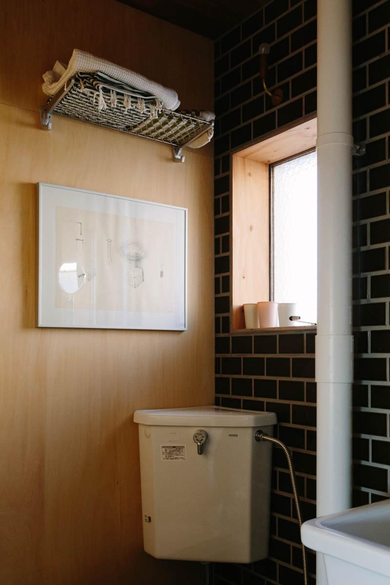 千葉県美浜区幸町の売買物件/トイレの一角。タイルと木の壁にワイヤーシェルフが似合います