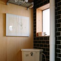 千葉県美浜区幸町の売買物件/トイレの一角。タイルと木の壁にワイヤーシェルフが似合います