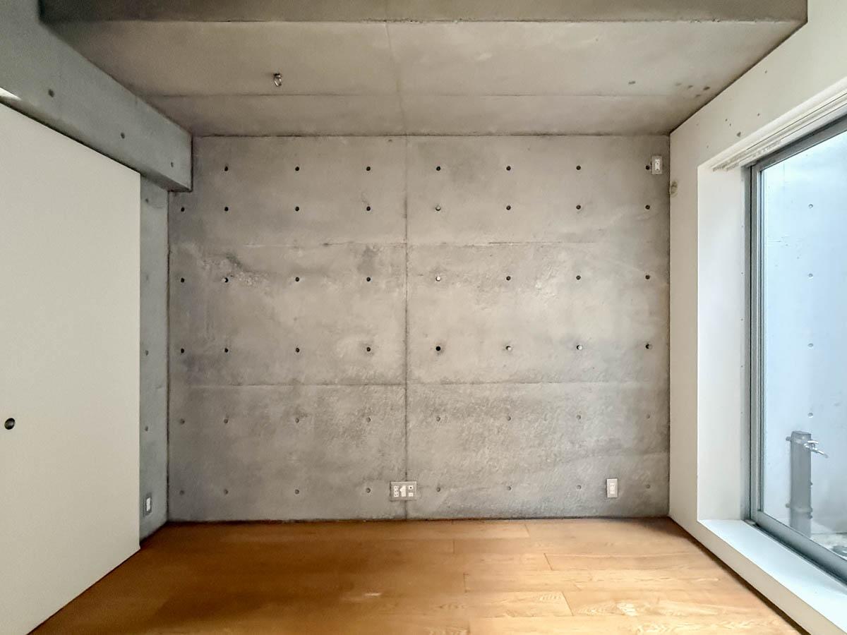 世田谷区世田谷の賃貸物件/洋室。コンクリートの壁面はピーコンの穴が活用できるようになっていて金具や棚などが設置可能