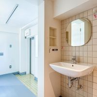 中野区中野の賃貸物件/丸いミラーとタイルの組み合わせがかわいい洗面。玄関のたたきは黄色いタイルで仕上げています（405号室）