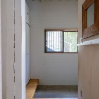 文京区白山の賃貸物件/玄関まわり。無骨なモルタルの床と、格子窓