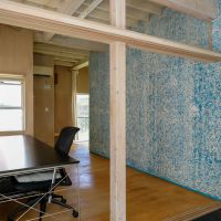 文京区白山の賃貸物件/青がまだらに散る木毛セメント板の壁と、デスク（撤去相談）