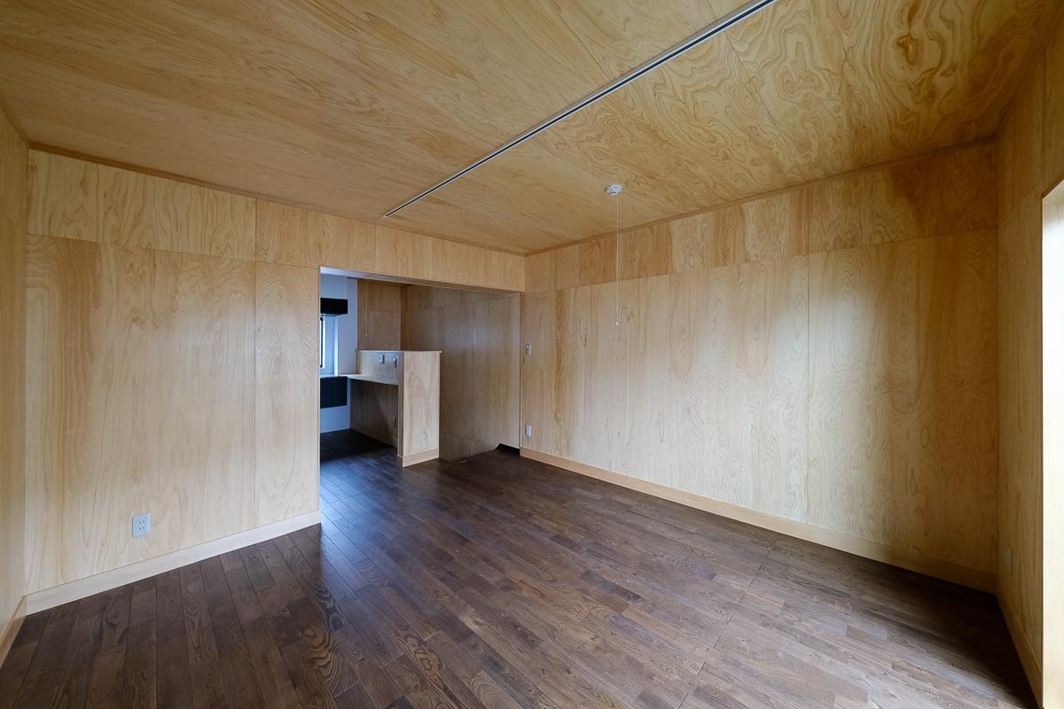 大田区田園調布の賃貸物件/2階のリビング。少し濃いめに塗装した無垢フローリング、板張りの壁、天井とシンプルな内装