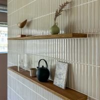 横浜市長津田町の売買物件/ダイニング横のタイル壁。合板の棚に小物が置ける