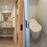 狛江市岩戸北の売買物件/洗面台と脱衣室、洗面台の右手にあるトイレ　トイレは引き戸です