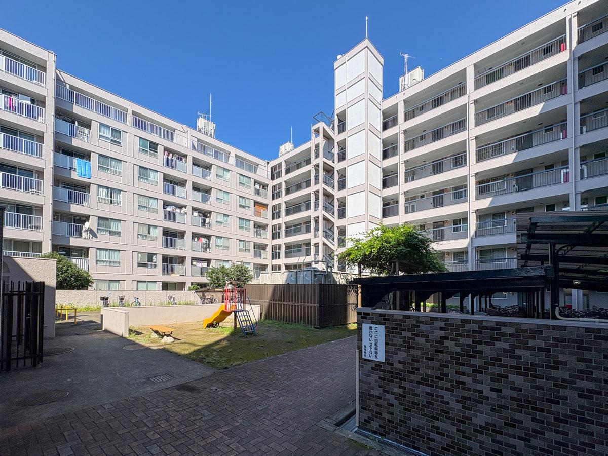狛江市岩戸北の売買物件/建物は大きな「コ」の字形になっていて、内側には自転車置き場や、滑り台のある広場がある