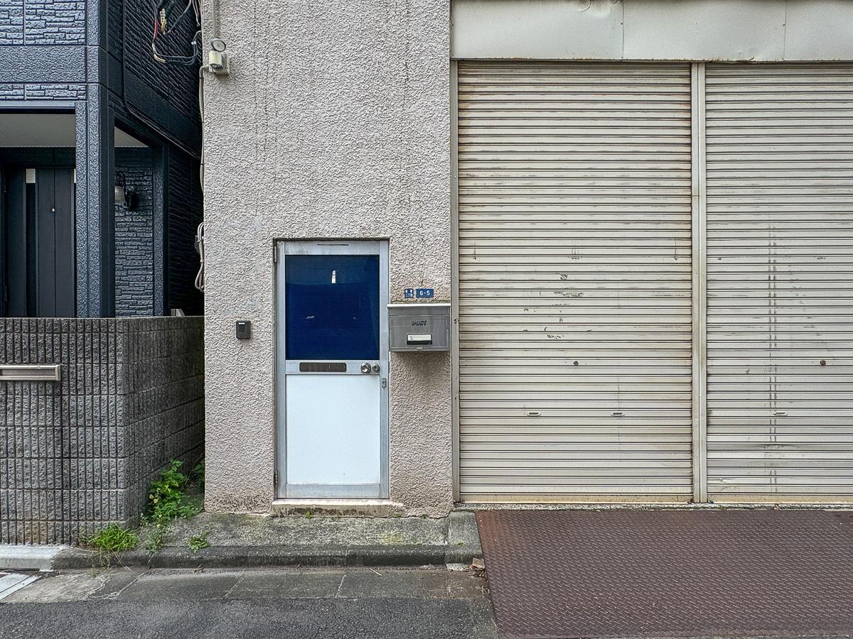江東区佐賀の賃貸物件/シャッター横に小さな出入り口。現在1階は駐車場と資材置き場として使われています
