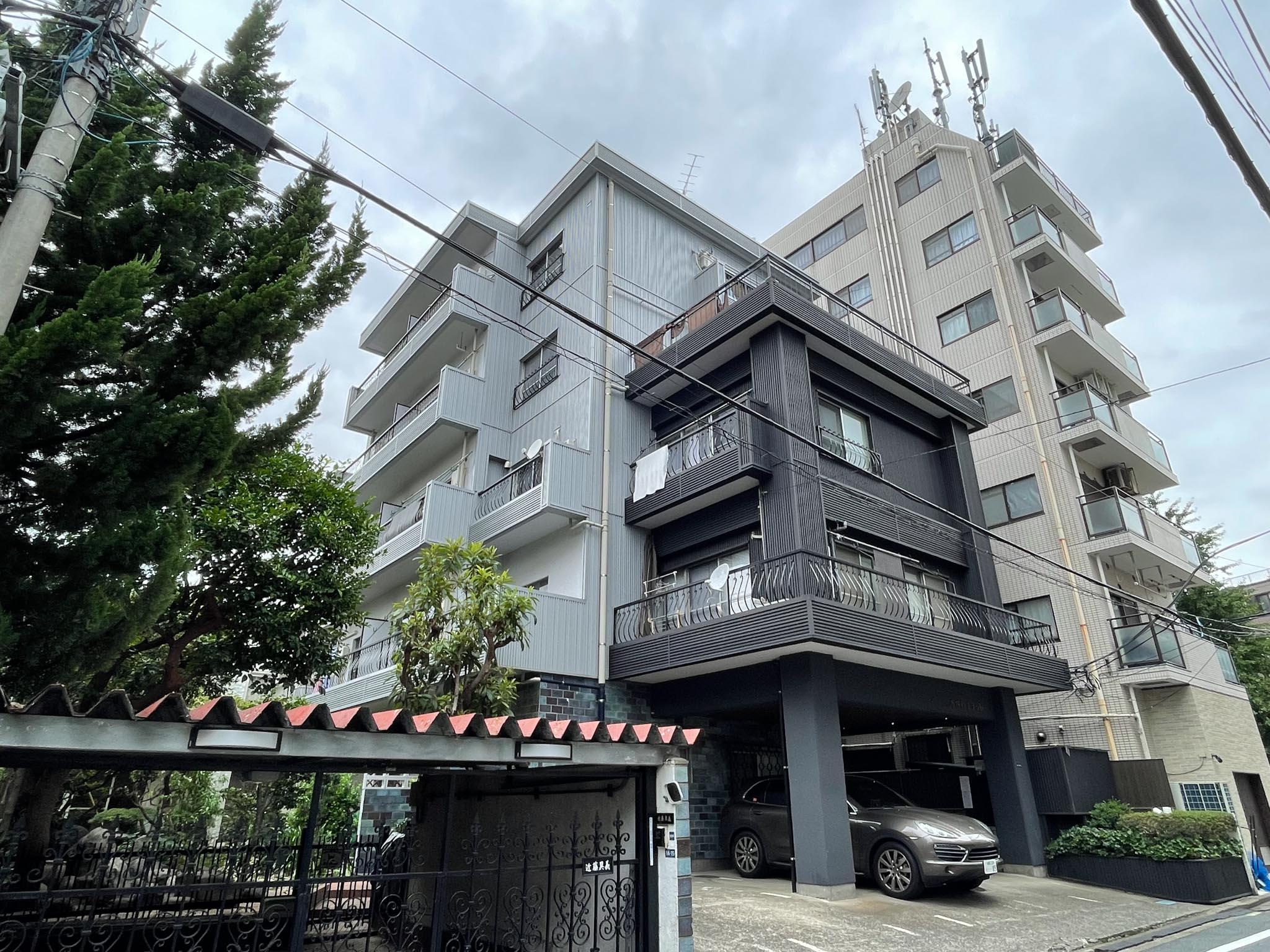 新宿区市谷台町の賃貸物件/ガルバリウム鋼板で外観を覆う修繕が施されたレトロマンション。ところどころに、元のタイルが顔を覗かせています