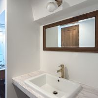 新宿区新宿の賃貸物件/洗面台。木枠で囲われた鏡が印象的