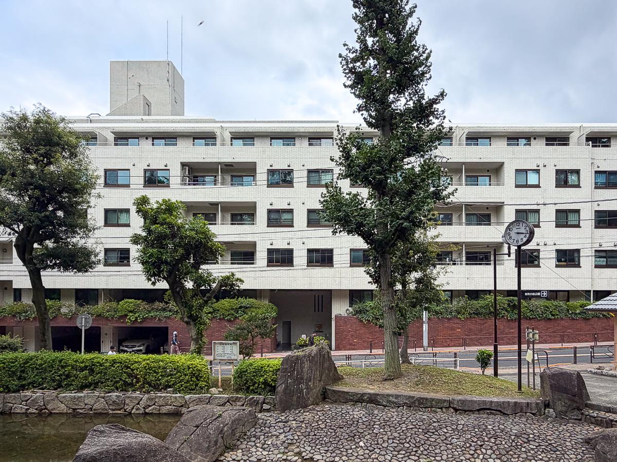 文京区小石川の賃貸物件/占春園のベンチからみたマンション外観