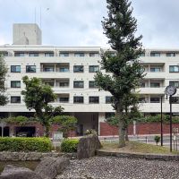 文京区小石川の賃貸物件/占春園のベンチからみたマンション外観