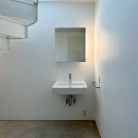 中野区新井の賃貸物件/一階のモルタル床の空間には洗面台のみが配置されたシンプルなスペース。